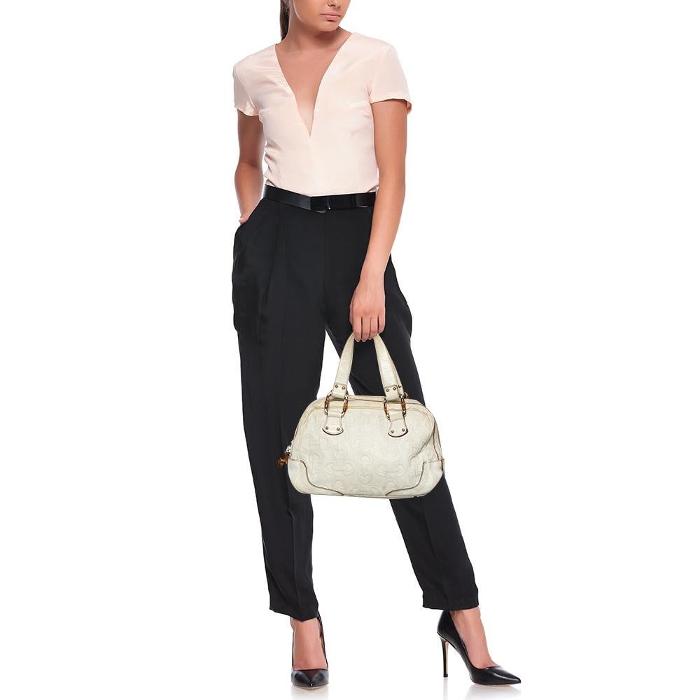 Diese Satchel aus dem epochalen Haus Gucci wurde fachmännisch aus cremefarbenem Leder gefertigt, das mit dem für das Label charakteristischen Pferdekopfmotiv geprägt ist. Sie verfügt über einen Reißverschluss, der zu einem leicht zugänglichen