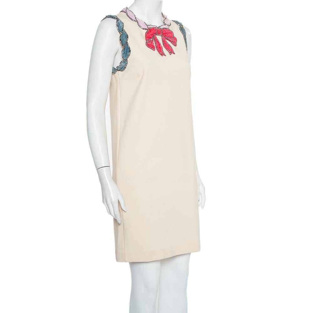 A glamorous appeal is what this shift dress from Gucci exudes! The cream knit creation features eye-catching crystal-embellished velvet trim details on the neckline and around the armholes. It comes with a zip closure at the back and will look great