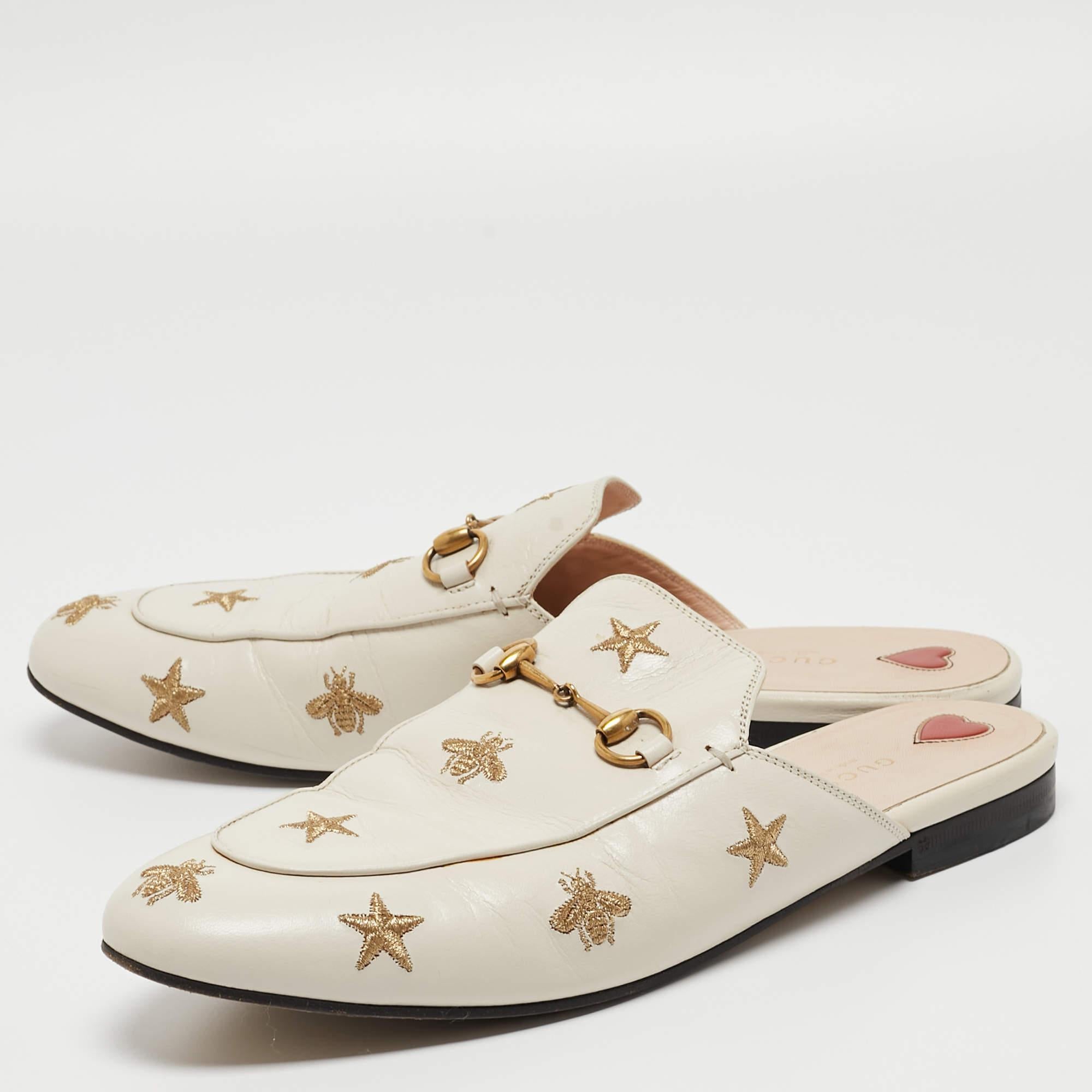 Indulge in luxurious sophistication with the Gucci Princetown Flat Mules. Crafted from sumptuous cream leather, these exquisite mules feature intricate bee and star embroidery, elevating any ensemble with unparalleled elegance and charm.

