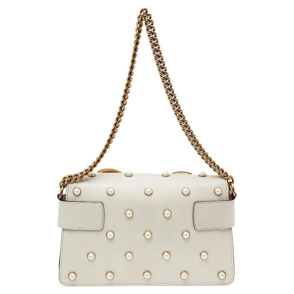 As one of the world's leading luxury fashion brands, Gucci continually offers creations that you can invest in. This cream Broadway Pearly Bee shoulder bag is crafted from leather into an elegant silhouette. It has a front flap closure on which