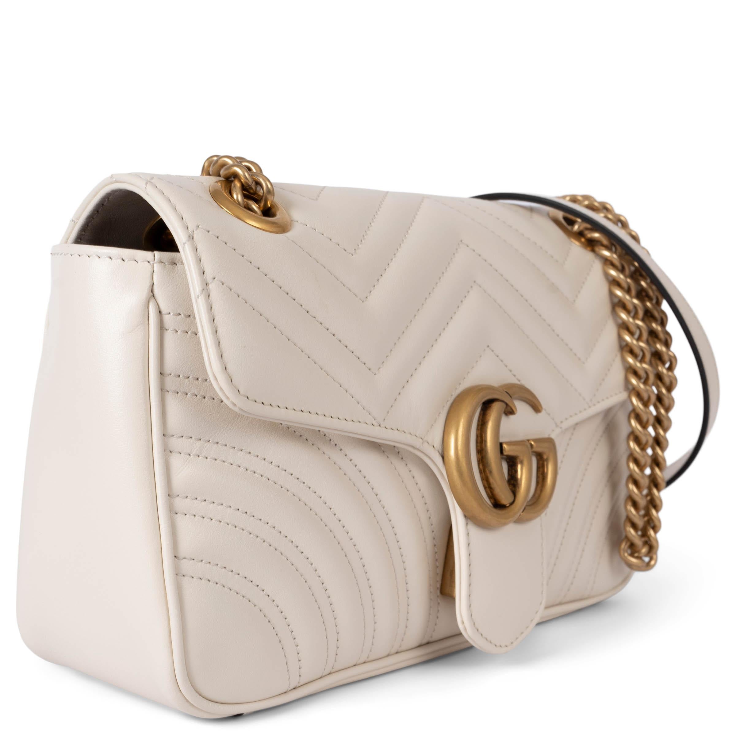 This 100% authentic Gucci GG Marmont Mini Matelassé Shoulder Bag is crafted in luxurious ivory chevron leather, featuring a charming heart detail on the back. The bag boasts a softly structured silhouette and a flap closure adorned with the iconic