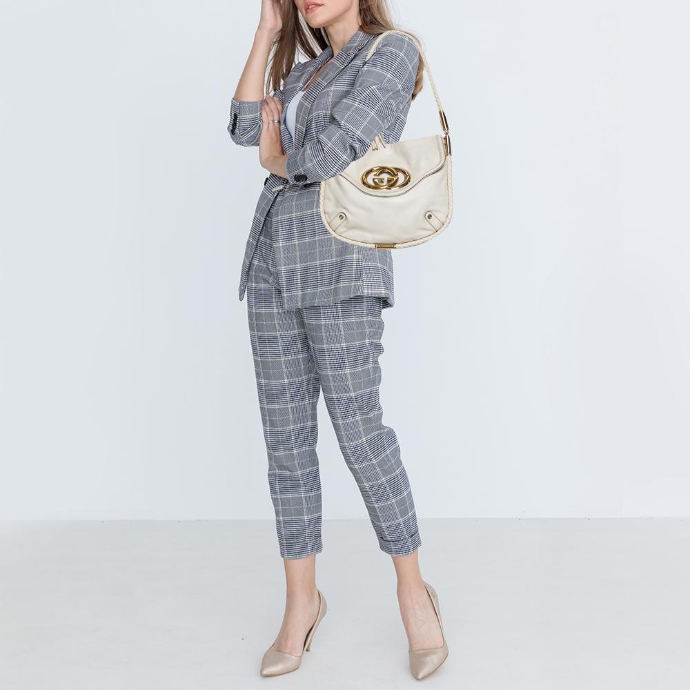A stunning companion for your outings, this wondrous Britt hobo by Gucci is one of its kind. It has been crafted in cream leather. The exterior features a braided trim extending to form a shoulder strap with fringed tassel and gold-tone