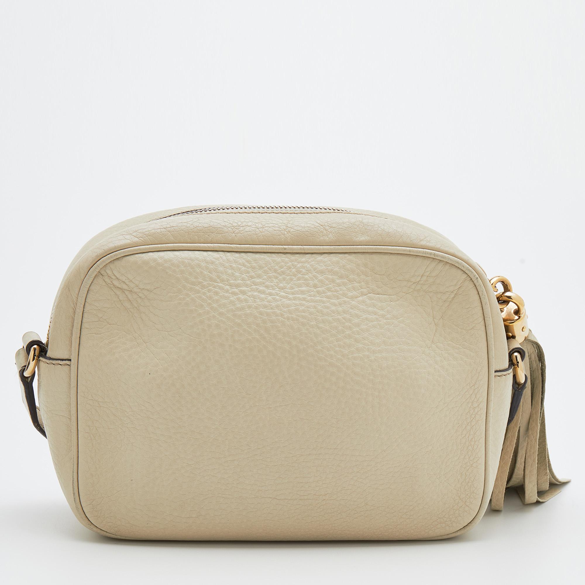 Gucci's expertise in creating noteworthy designs is evident in this Soho bag. Made from cream leather, it gets a luxe update with a brand motif on the front and displays a shoulder strap. The zipper closure at the top is equipped with a