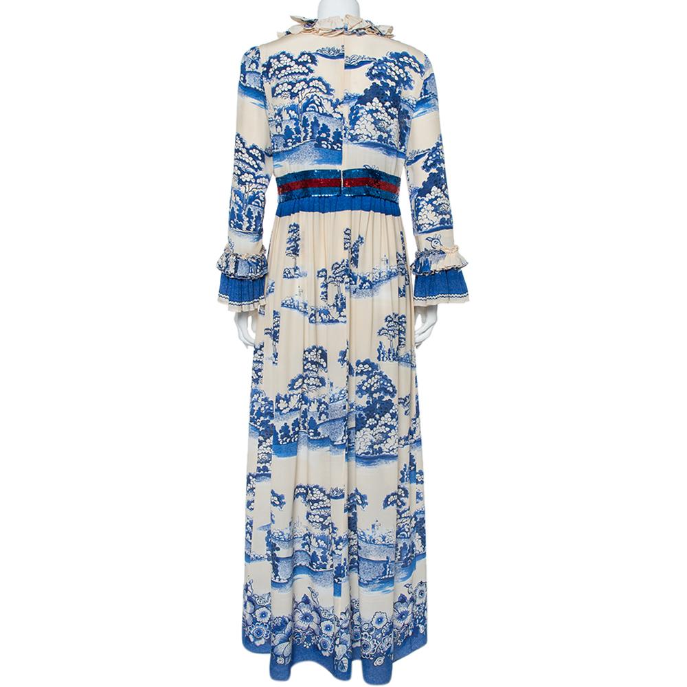 Este precioso maxi número de Gucci te garantizará un estilo glamuroso. Esta creación en color crema y azul marino presenta una favorecedora silueta plisada, salpicada con un precioso estampado de jardines de porcelana y adornada con detalles de