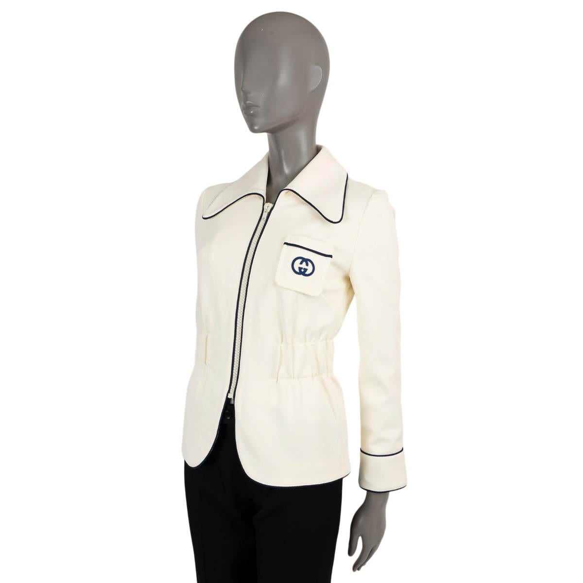 Veste en jersey de polyamide ivoire (100%) avec bordures bleu marine, 100% authentique Gucci GG. Ce modèle présente une fermeture à glissière sur le devant, des poignets zippés, une poche plaquée sur la poitrine et une taille élastique. Doublée en