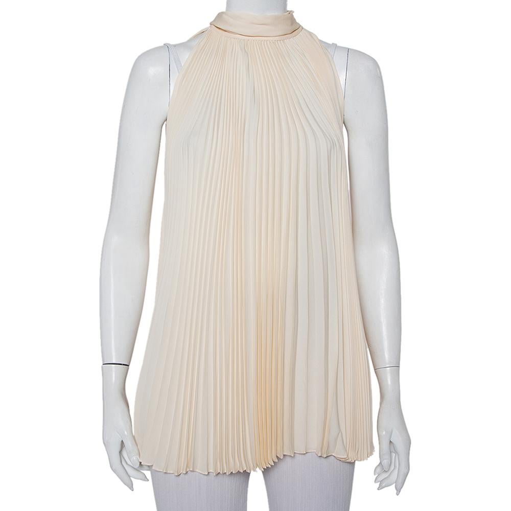 This top beautifully illustrates Gucci's approach to elegant designs. Cut from cream plisse silk, it has an oversized silhouette with a sleeveless style. The neck is adorned with a neck-tie detail. Style it with pants and heels.

