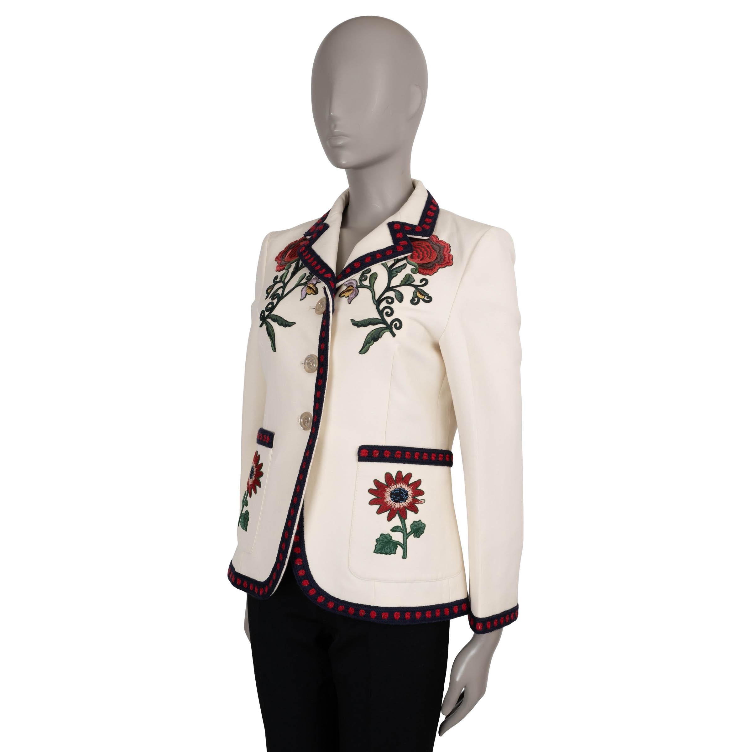 This 100% authentic Gucci blazer in cream silk (53%) and cotton (47%) is a vibrant expression of the house’s romantic aesthetic. Adorned with intricate multicolour floral embroidery, it features a fitted silhouette with notched lapels, 3/4 sleeves,