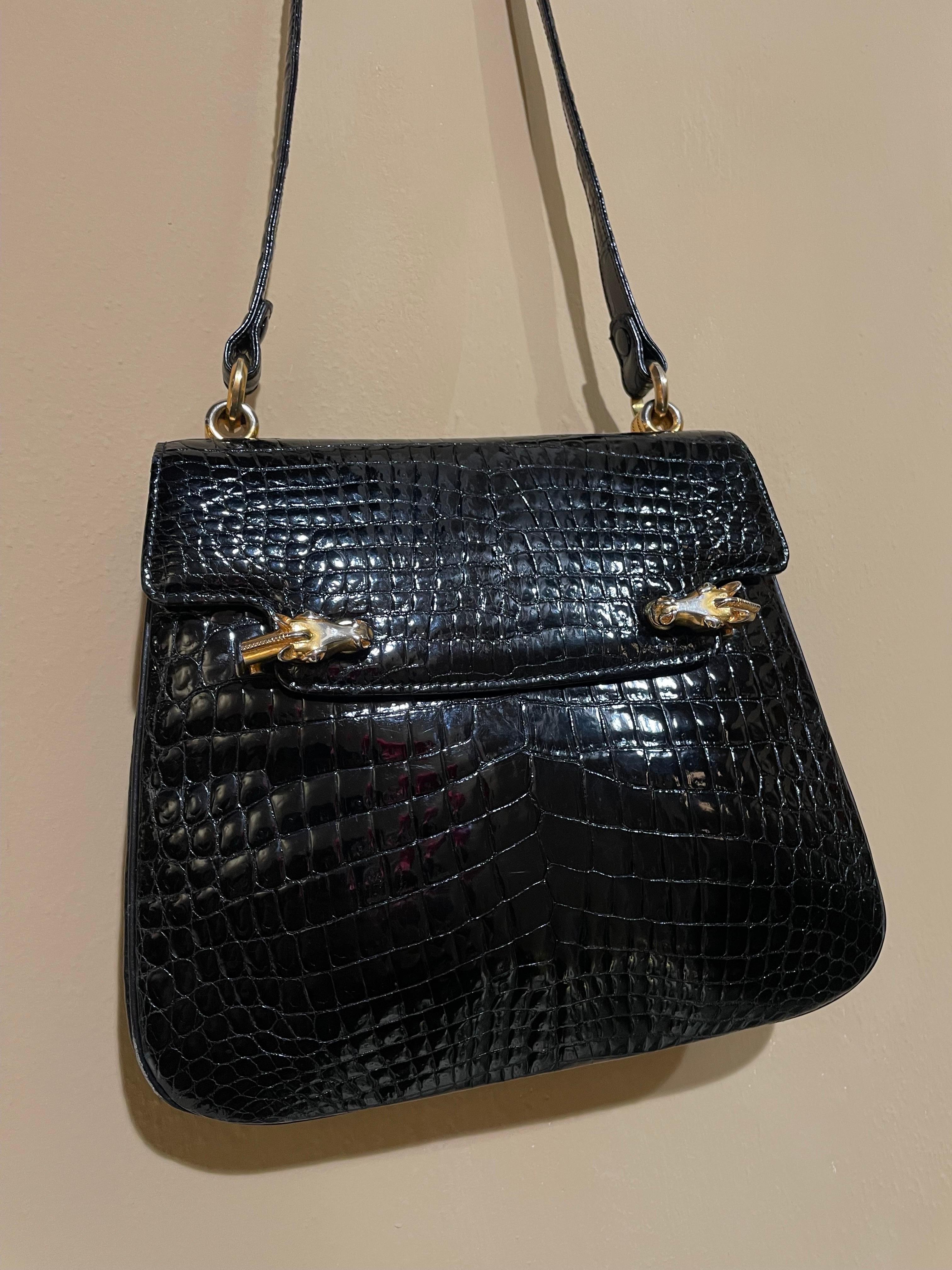 Gucci crocodile bag from 1960, the same model owned by Elisabeth Taylor.
Very special closure with flap and two golden metal horse heads that rise in interlocking. Interior consists of one pocket plus two side pockets, one of which is closed with