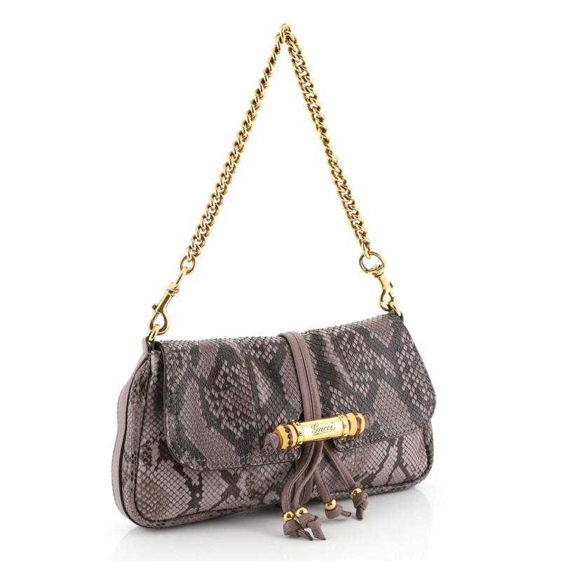 This Gucci Croisette Evening Bag Python, crafted in genuine purple python, features a detachable chain strap that converts into a clutch, engraved Gucci script bullet, bamboo detail, and gold-tone hardware. Its flap opens to a purple leather