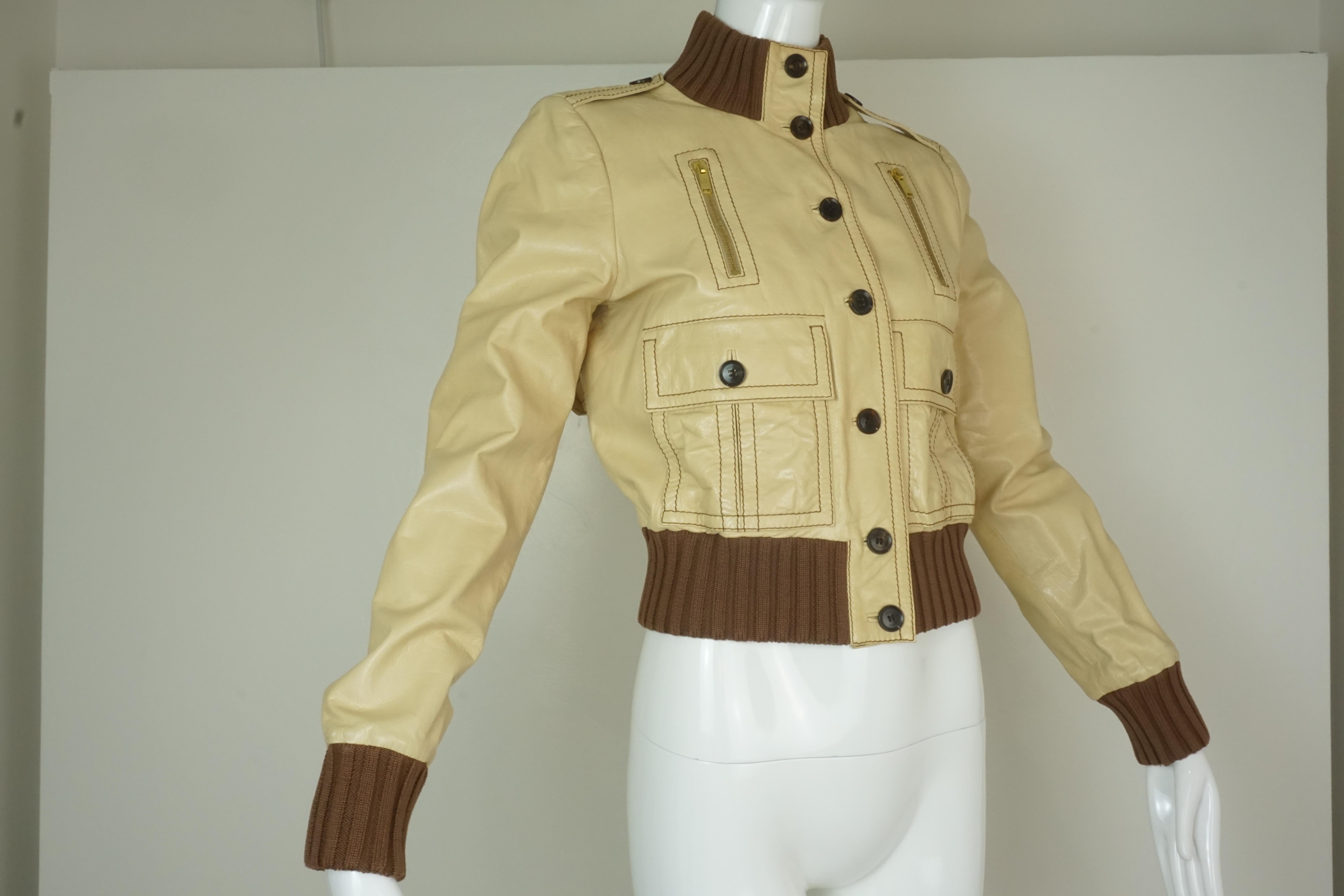 Gucci Light Tan Leather Cropped Bomber Jacket w/ Button Front, Knit Cuffs & Collar, Front pockets, and Adjustable Buckles at sides. Brown GG Gucci lining. Size 42/6. Made in Italy.

Foxy Couture is not an authorized reseller nor affiliated with any