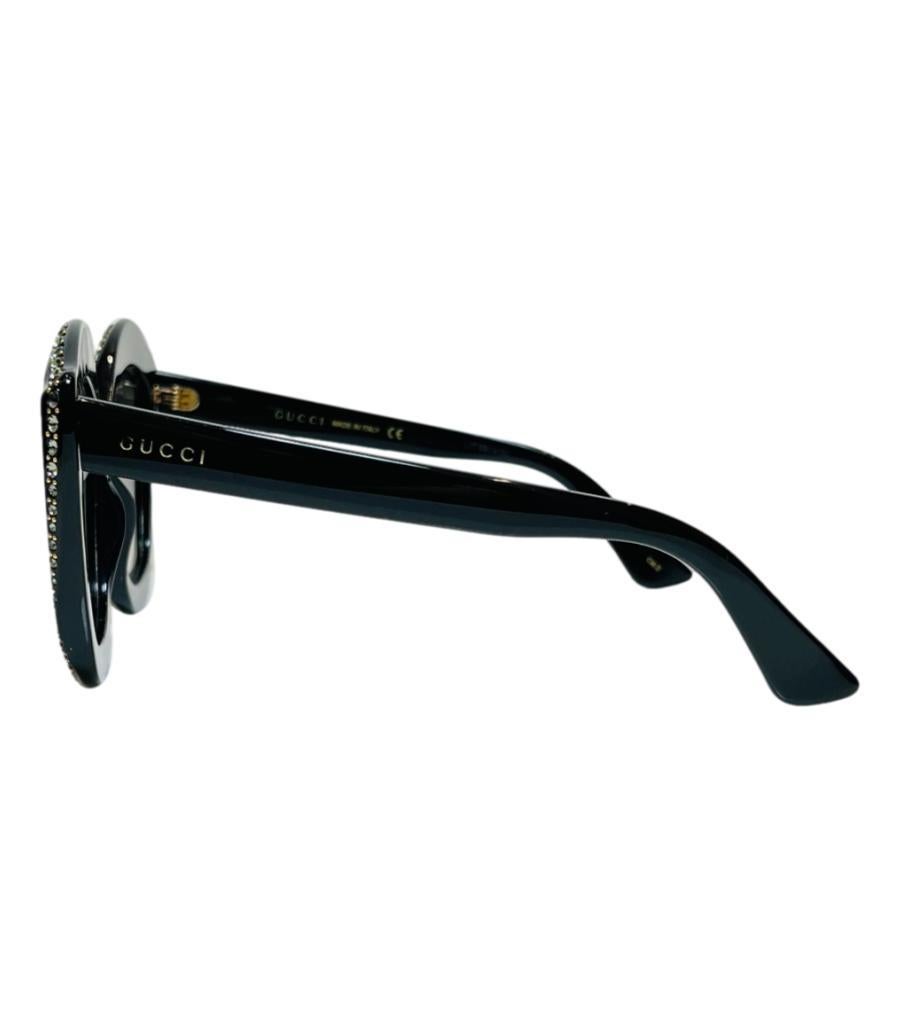 Gucci Crystal Cat-Eye-Sonnenbrille aus Kristall
Schwarze gerahmte Sonnenbrille mit Kristallbesatz.
Mit grau getönten Gläsern und Gucci