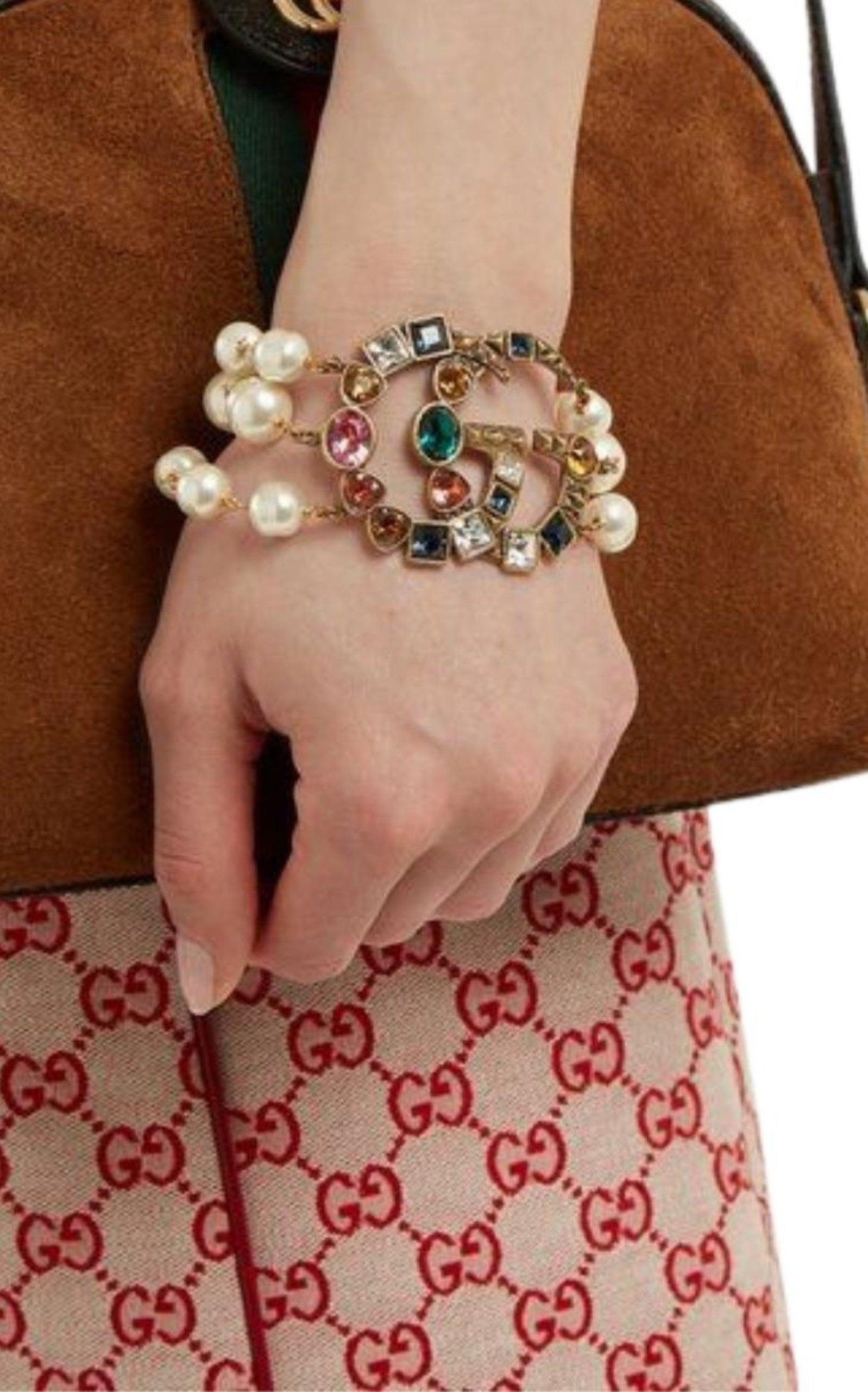 Pulsera de perlas de tres vueltas, con adornos de piedras y el emblemático logotipo GG de Gucci.
Adornada con perlas y cristales, la doble G está engastada en una pulsera con efecto perla.
Detalles de GG
Metal con acabado en oro