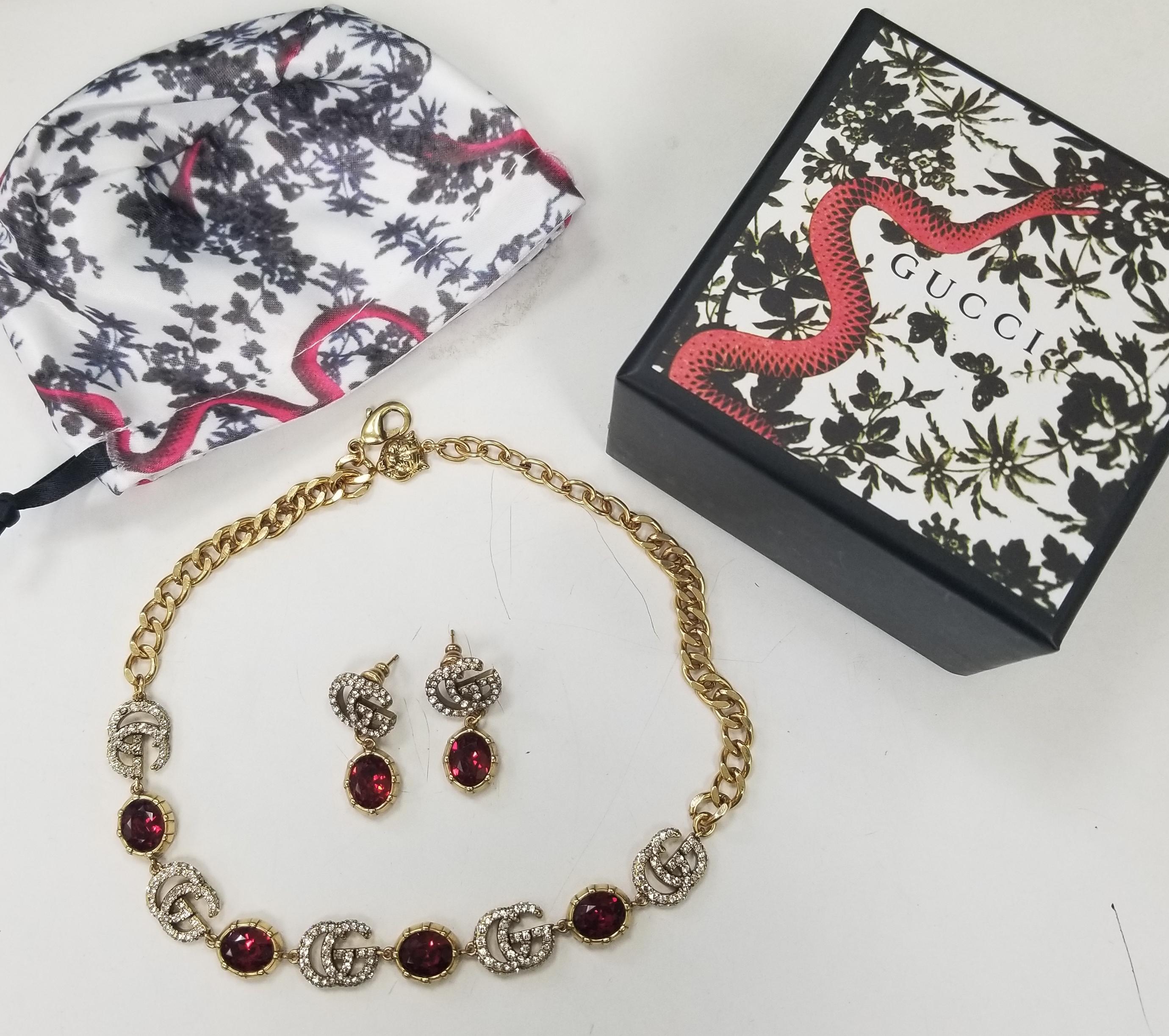 A Red faceted crystal pendant combines with the crystal Double G detail, forming a sparkling pendant that completes these earrings in aged gold-toned metal and matching necklace with adjustable length.

    Metal with aged gold finish
    Crystal