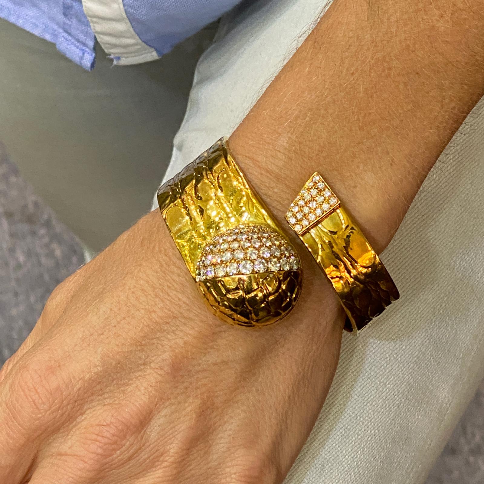 One of a kind custom made bracelet by Italian designer Gucci. This 1970's bypass diamond cuff is fashioned in textured 18 karat yellow gold. The bange features 87 round brilliant cut diamonds weighing approximately 6.33 carat total weight and graded