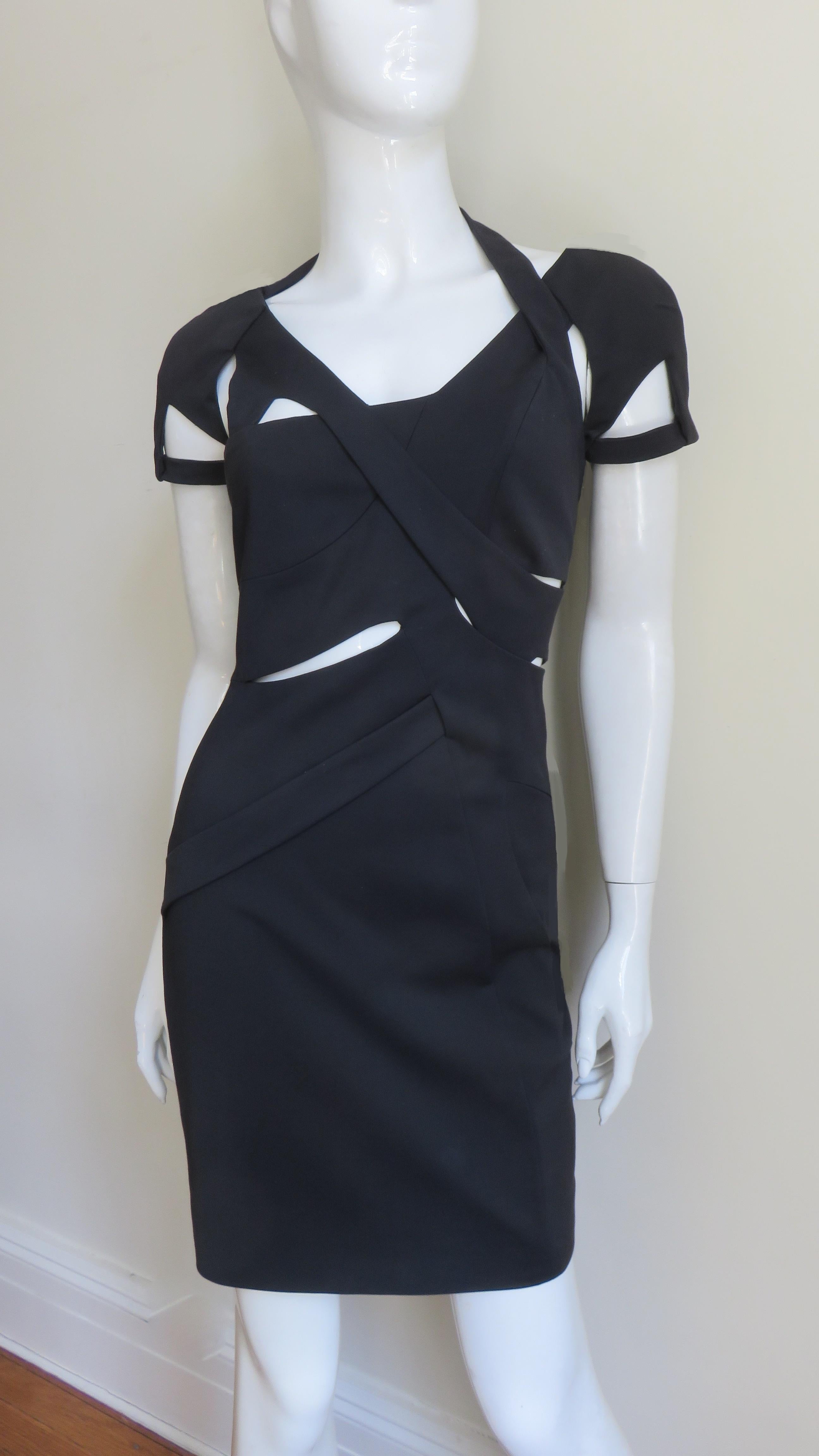 A fabulous black stretch fitted dress from Gucci as worn by Rhianna on the 2010 cover of W magazine.  It has short sleeves plus asymmetric seaming, straps and cut outs through out the front and back bodice.  It  has a bit of stretch for a great fit,
