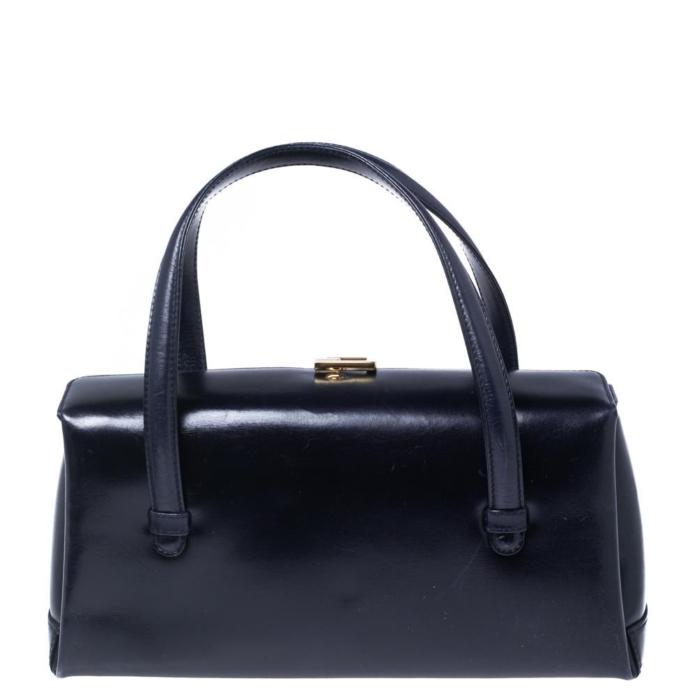 This mesmerizing satchel is from the house of Gucci and it comes in a luxurious dark blue hue. It has been made from leather and features a G flap at the top along with two handles. The square-shaped bag has gold-tone hardware and an extensive