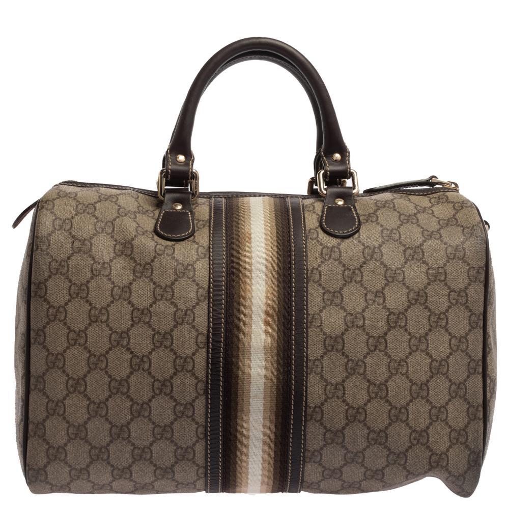 This Boston bag from Gucci is truly charming and comes finely crafted from the signature GG canvas and leather. It is styled with the brand's well-known Web detailing and flaunts dual-rolled handles and a top zip closure that opens to a capacious