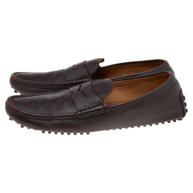 Les mocassins comme ceux de Gucci valent leur pesant d'or car ils incarnent à la fois le confort et le style. Ces mocassins sont réalisés en cuir diamanté marron foncé sur l'extérieur, avec une lanière Penny décorant l'empeigne. Elles présentent un