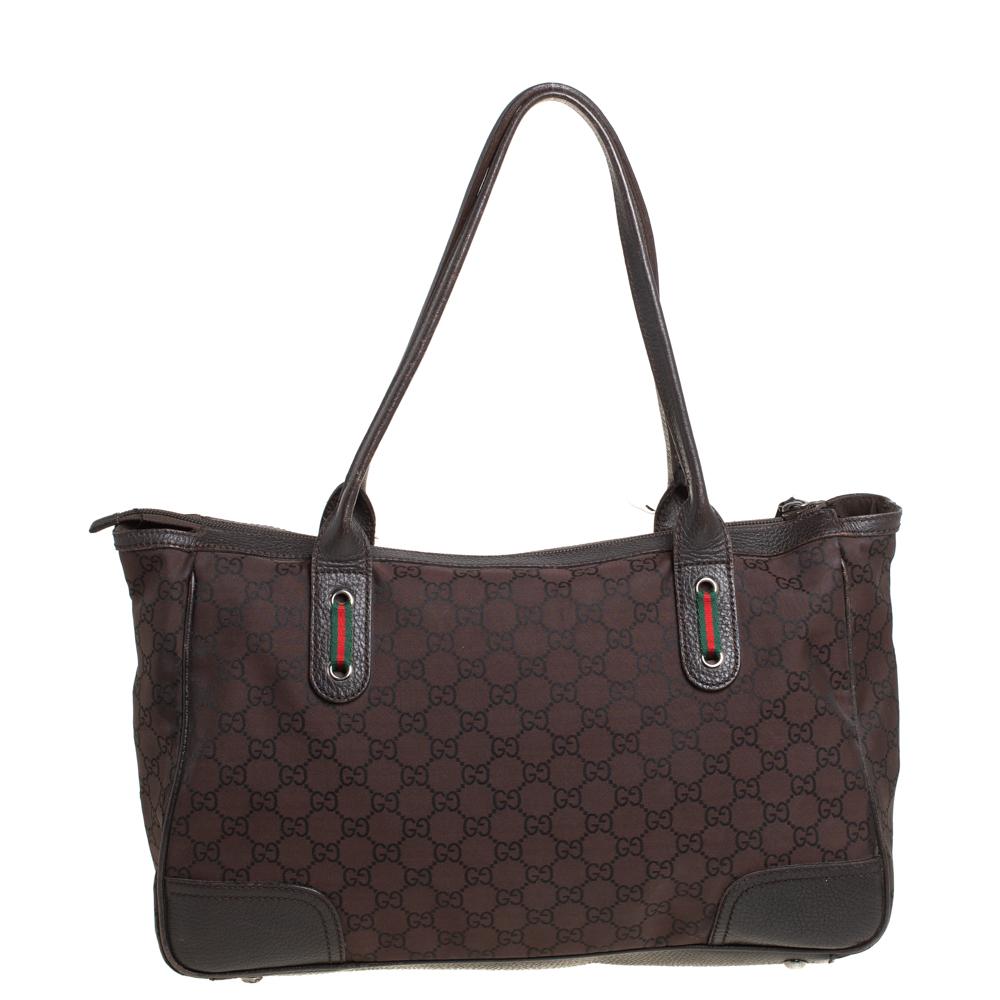 Crafted from GG nylon and leather, this bag from Gucci is designed with minimal style details but with high attention to craftsmanship so that it may assist you with durability. The spacious interior is lined with fabric and the bag is held by two