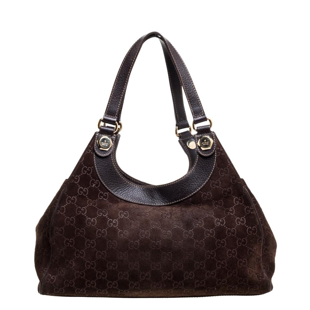 The dark brown suede exterior flaunts signature GG symbols and the quality canvas lining ensures the safety of your essentials. This Charmy tote by Gucci makes has a relaxed shape and an impeccable finish. Held by leather handles, this bag is a good