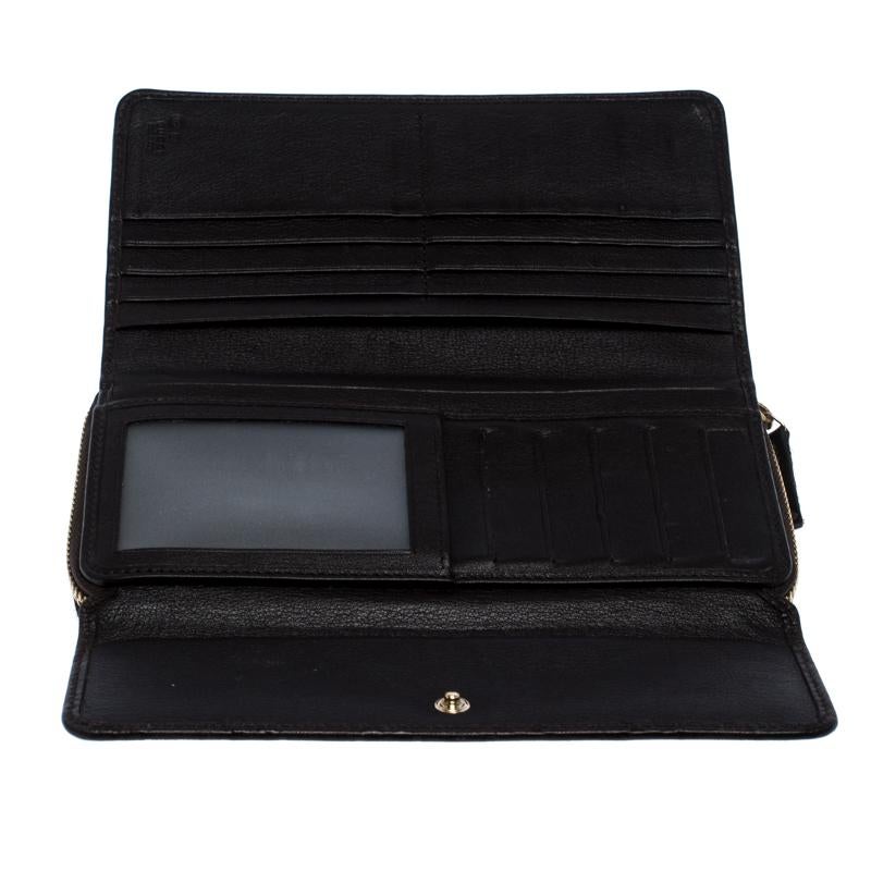 Gucci makes sure you stay at the top of your accessory game with this continental wallet. A subtle yet attractive dark brown shade characterizes the sturdy Guccissima leather exterior. It has a front flap, a zip closure, a leather and fabric
