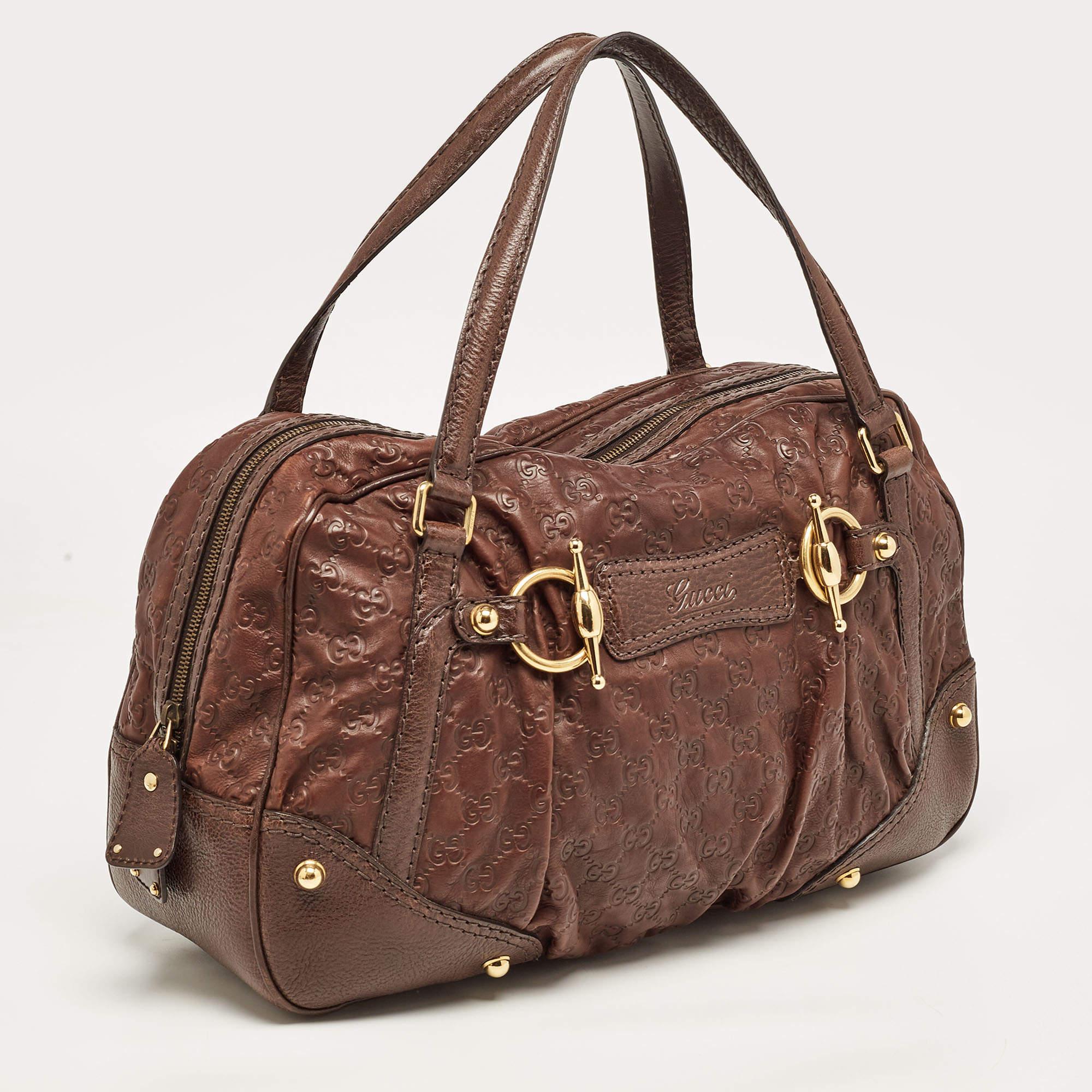 A timeless and elegant piece to add to your collection. Jockey Boston bag is designed with Guccissima leather. Roll on handles makes it easy for you to tote this bag in your arms. Gold-tone hardware works well on the dark brown contrast combination.