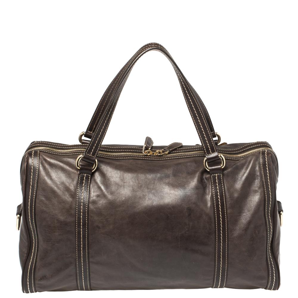 A truly posh and elegant piece to add to your collection, this Gucci bag is highly versatile and stylish. This Boston bag is crafted from dark brown leather and styled with a gold-tone metal bow detail on the front. The creation features a top zip