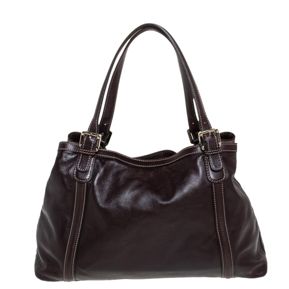 The iconic Gucci label is renowned for its rich heritage and classic styles. This tote is made from leather and comes with dual top handles. It features a gold-tone GG logo embellished at the front. The fabric-lined interior houses a zipped pocket
