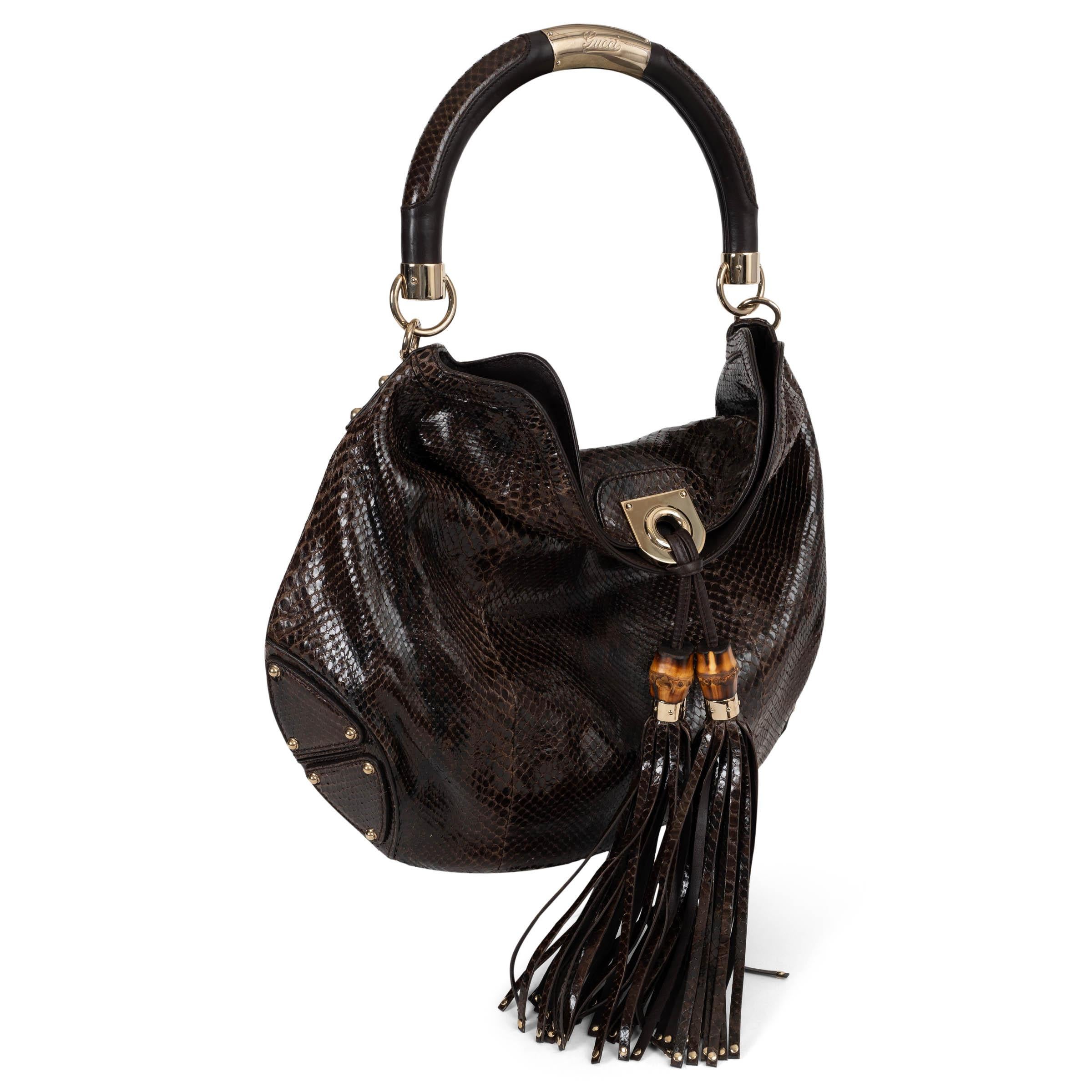 This 100% authentic Gucci Indy hobo in dark brown python skin is a striking blend of exotic luxury and signature house detailing. Featuring a structured tubular top handle inlaid with python and centered with an engraved metal Gucci plate, it also