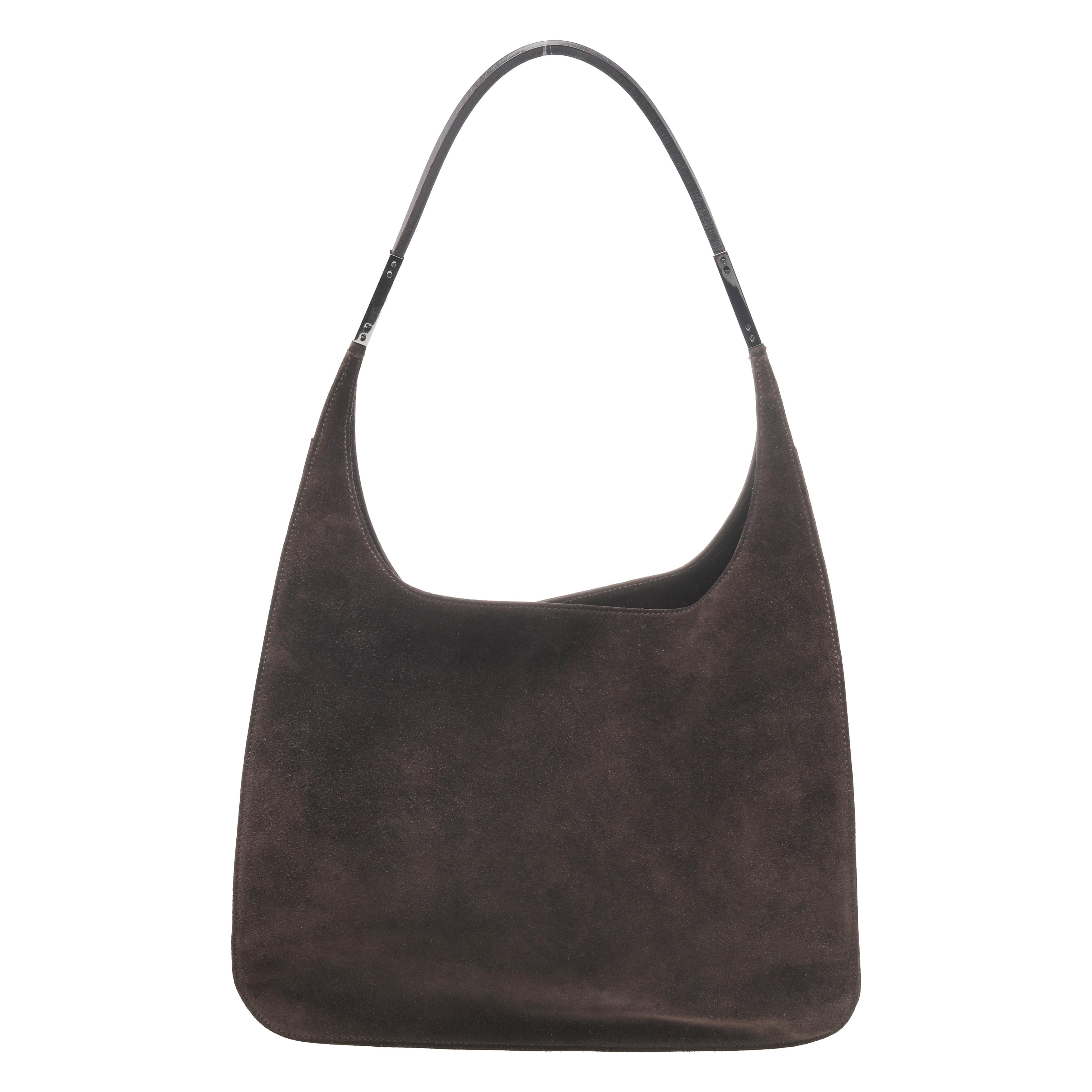 This simple and striking shoulder bag by Gucci is a creation that will deliver chic looks every time. It has been crafted from dark brown suede and leather. It has a single strap, a zip closure, and a spacious leather interior. It is finished with