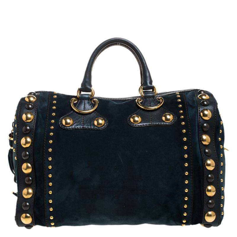 Crafted from dark green suede and leather, this Gucci number has tassels and a spacious fabric interior. It also features two handles, signature heart emblem and studs in gold-tone hardware. Flaunt this beauty wherever you go and you'll surely