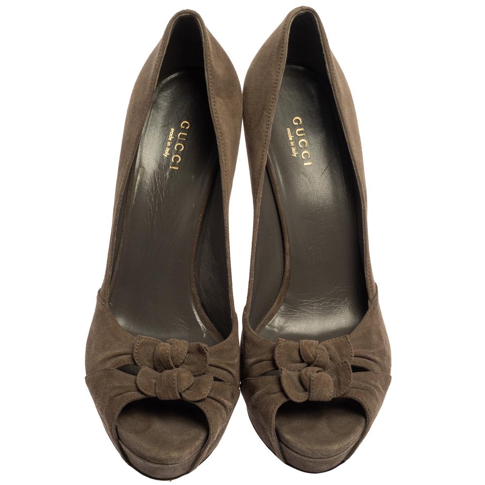 A timeless design that will amp up your look instantly, Gucci's pumps are a must-have for every woman's wardrobe. They have been crafted from suede in a dark grey shade and adorned with dual bows to form a peep-toe design. The pumps are elevated on