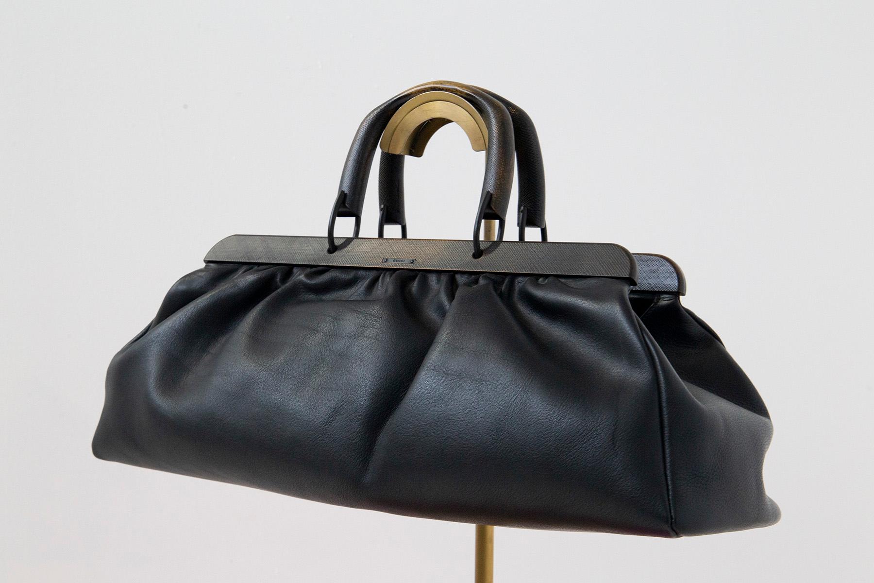 Gucci Day Bag Modell Doctor's Bag aus schwarzem Leder.
Gucci schwarzes gehämmertes Leder Seesack oder Tagestasche von Tom Ford namens Doctor's Bag. Das Besondere an der Tasche ist die Holzumrandung und die Griffe in Antikoptik. 
Das Gucci-Logo ist