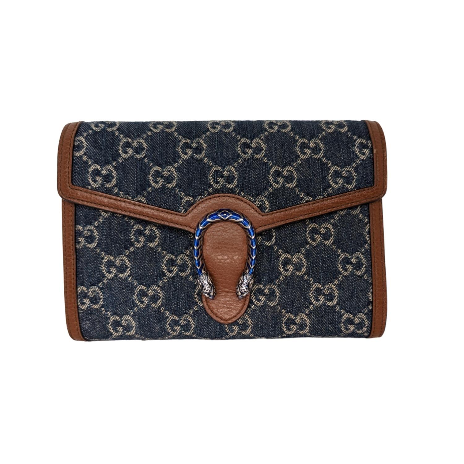 GUCCI Denim GG Monogram Mini Dionysus Chain Wallet in Blue and Ivory. This stylish bag is crafted of Gucci monogram in blue denim. This bag features an optional silver chain shoulder strap and a textured horseshoe closure with lion heads with blue