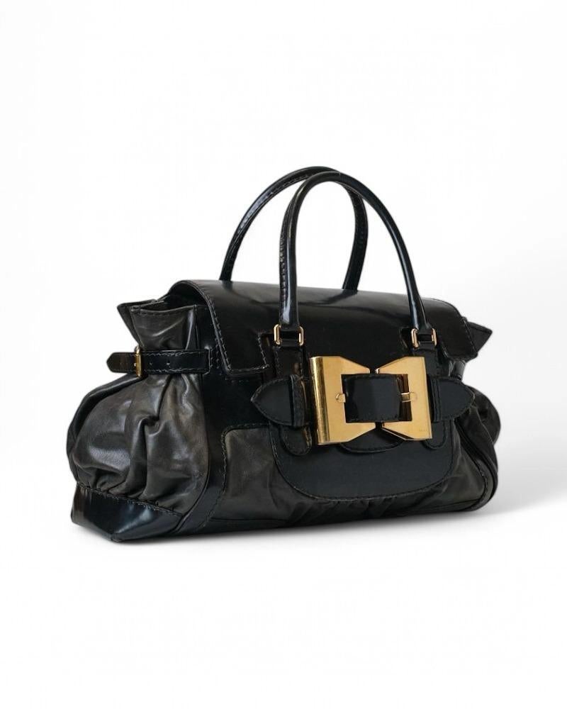 Die charakteristische Tasche von Gucci, Modell Dialux Queen, aus schwarzem Lackleder mit goldenen Beschlägen. Ausgestattet mit einer Frontklappe mit Magnetknopfverschluss und einem Innenfutter aus schwarzem Stoff mit praktischen Fächern, ist die