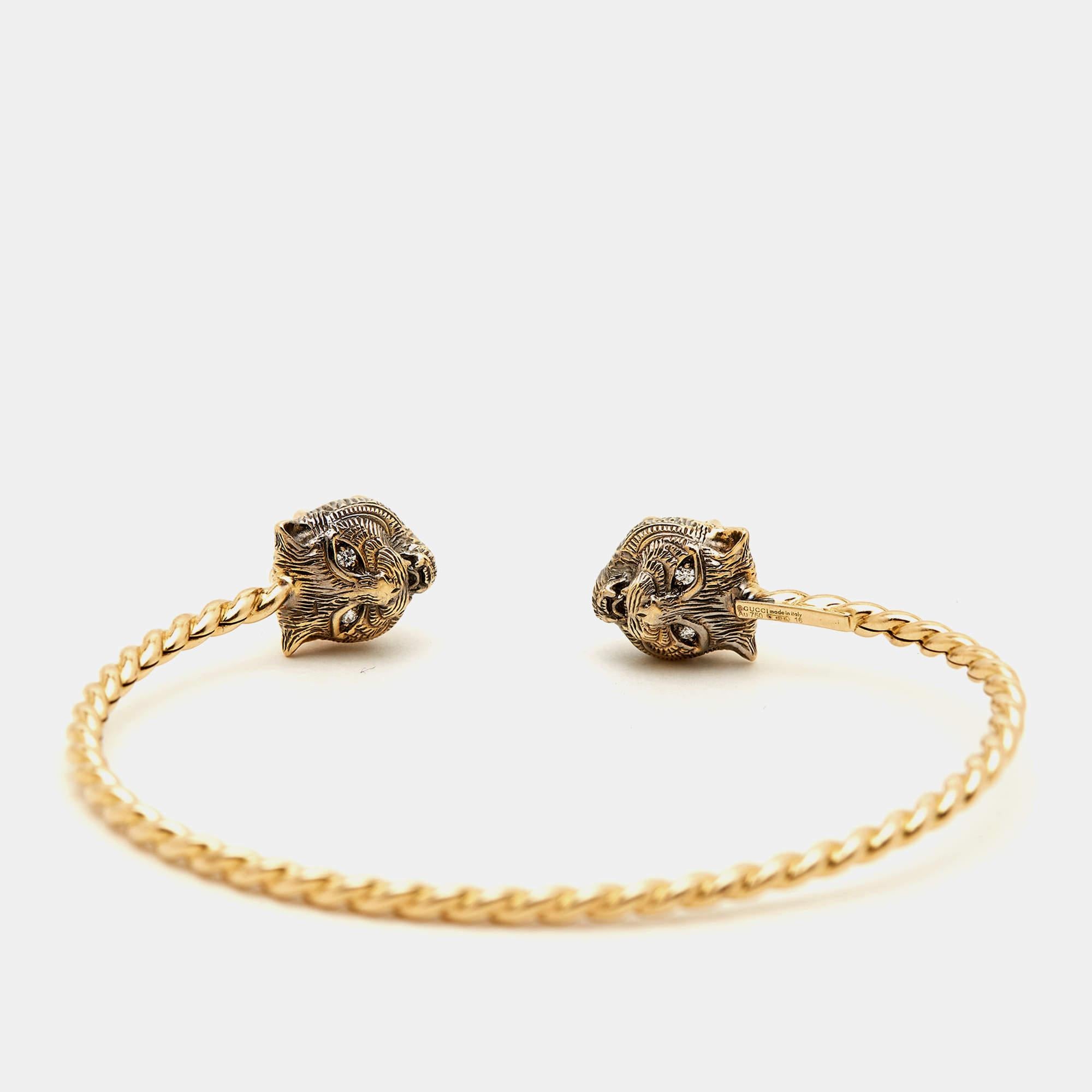 The Gucci Marche des Merveilles Feline cuff bracelet is a luxurious and captivating piece of jewelry. Crafted from 18K yellow gold, it features intricate feline head motifs adorned with sparkling diamonds, aquamarine, and pink tourmaline gemstones.