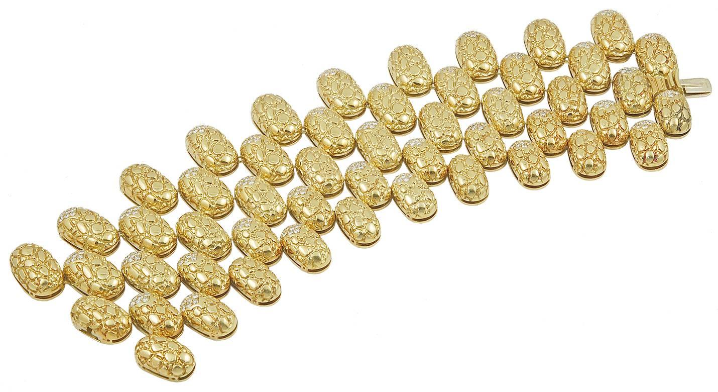 Bestehend aus einer prächtig gestalteten, fünfreihigen Halskette aus ovalen, strukturierten Goldbombengliedern, die abwechselnd mit Diamanten in Pavé-Fassung besetzt sind; einem Armband und einem Paar Ohrclips en suite, 14 Ins. (Halskette), 7 1/4