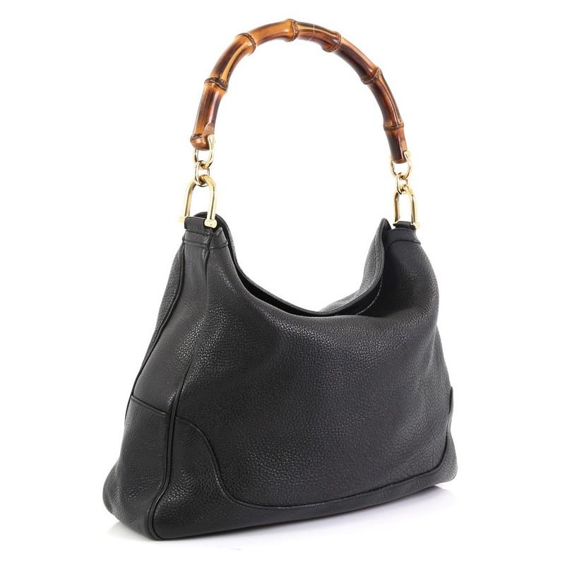 This Gucci Diana Bamboo Shoulder Bag Leather Medium, crafted from black leather, features a single looped bamboo handle and gold-tone hardware. It opens to a neutral fabric interior with side zip and slip pockets. 

Estimated Retail Price: