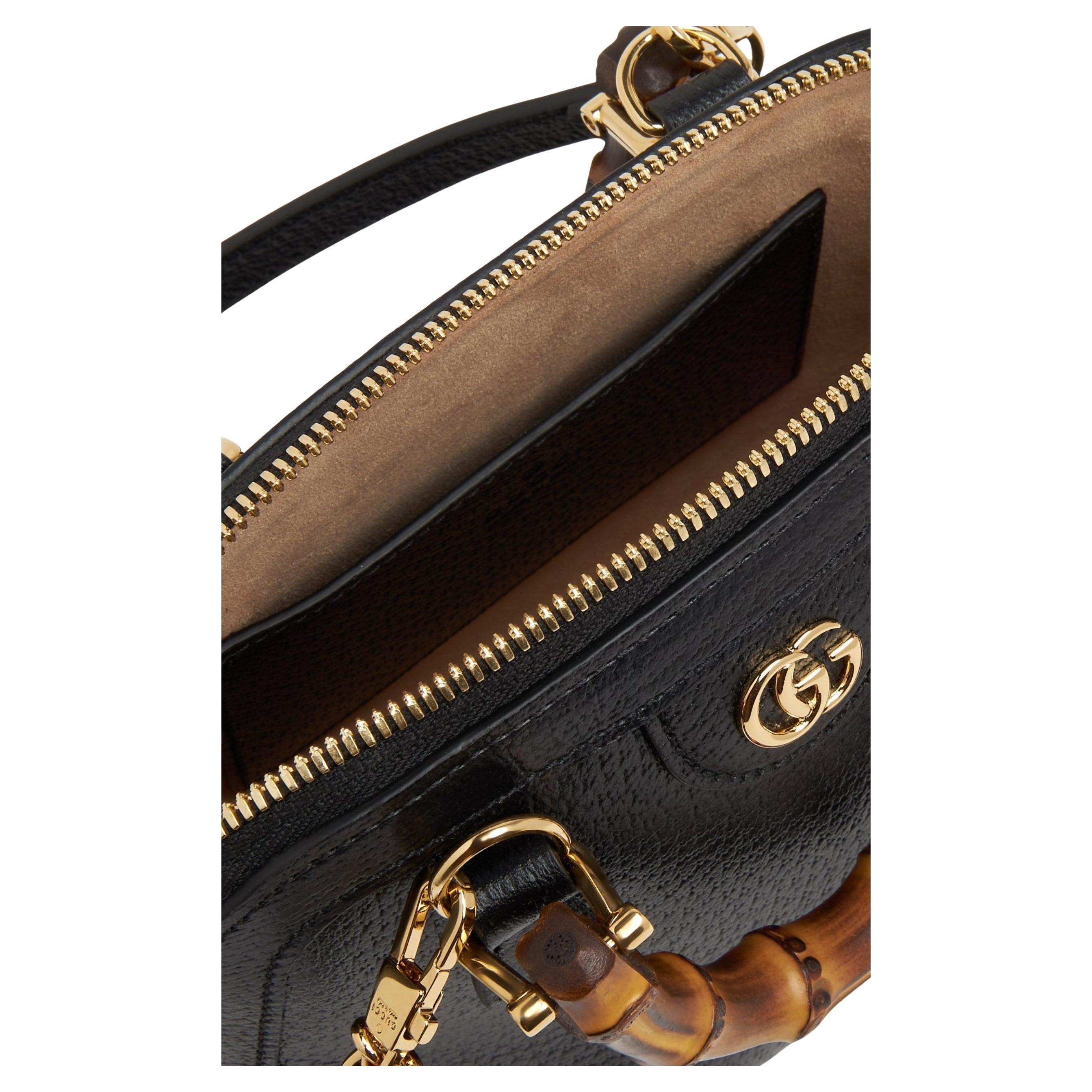 El Mini Tote Gucci Diana de piel negra presenta detalles dorados brillantes. Viene equipado con dos correas decorativas para ayudar a mantener la forma de las asas, como se muestra en la foto. El forro de microfibra tiene un lujoso acabado de