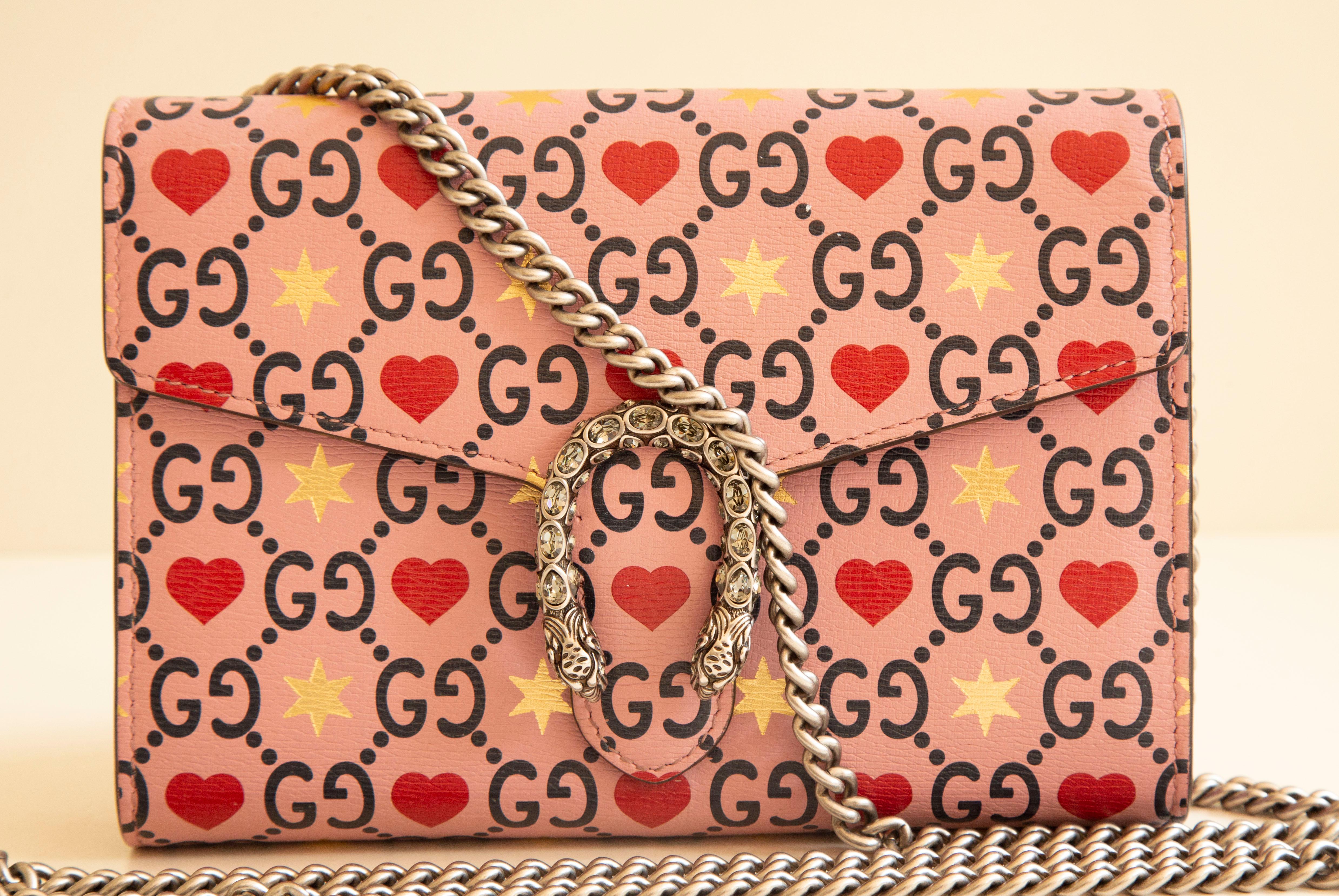 Gucci Dionizus wallet on chain/cross body bag/shoulder bag in limited edition Valentine's Day. The bag is made of embossed calfskin with the GG web on a pink background with heart and star decoration. The bag features silver tone chain strap (124