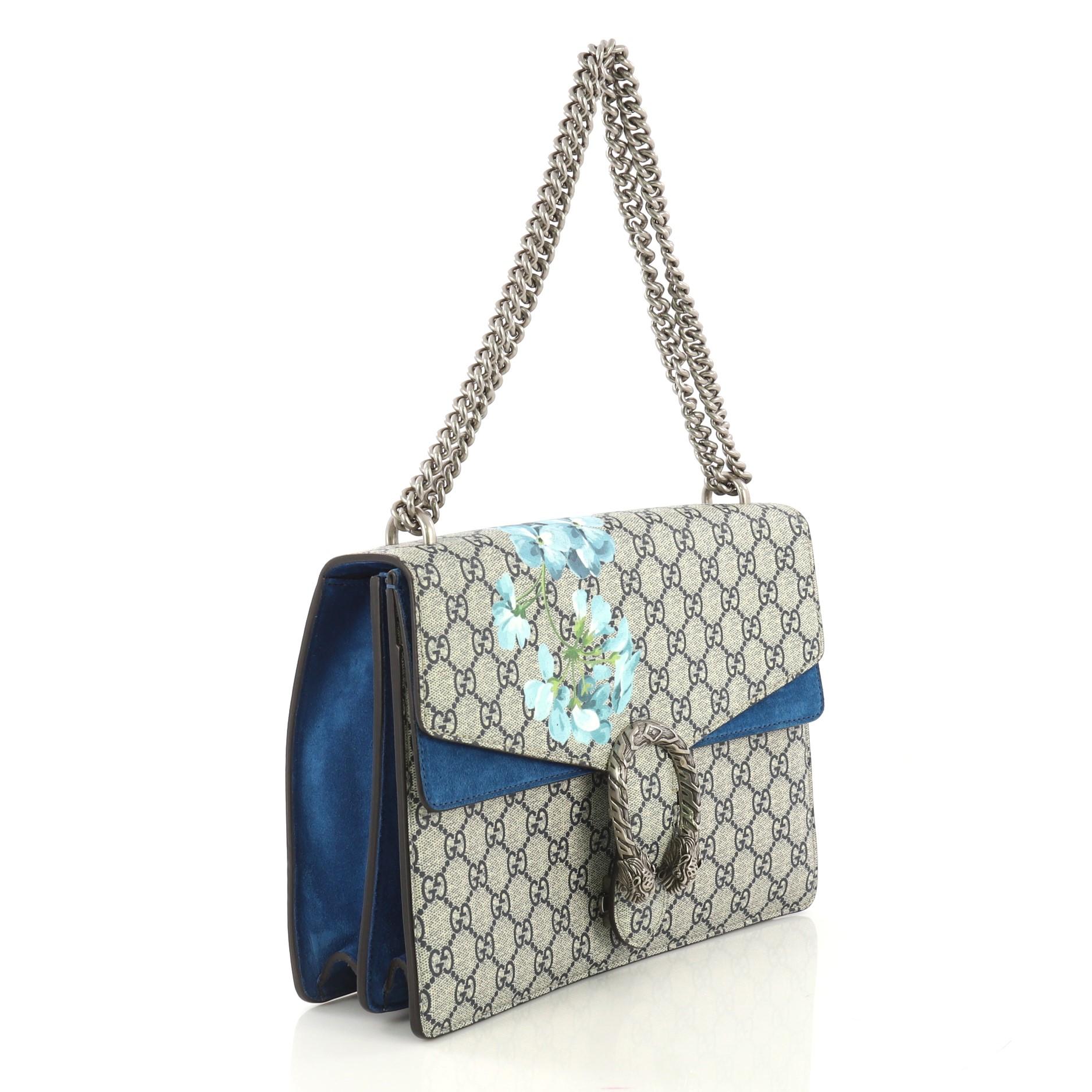 This Gucci Dionysus Bag Blooms Print GG Coated Canvas Medium, crafted from blue blooms print GG coated canvas, features sliding chain strap, tiger head spur detail, and aged silver-tone hardware. Its pin closure opens to a blue suede interior with