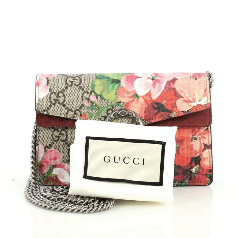 This Gucci Dionysus Bag Blooms Print GG Coated Canvas Super Mini, crafted from pink blooms print GG coated canvas, features sliding chain strap, tiger head spur detail, and aged silver-tone hardware. Its pin closure opens to a neutral microfiber