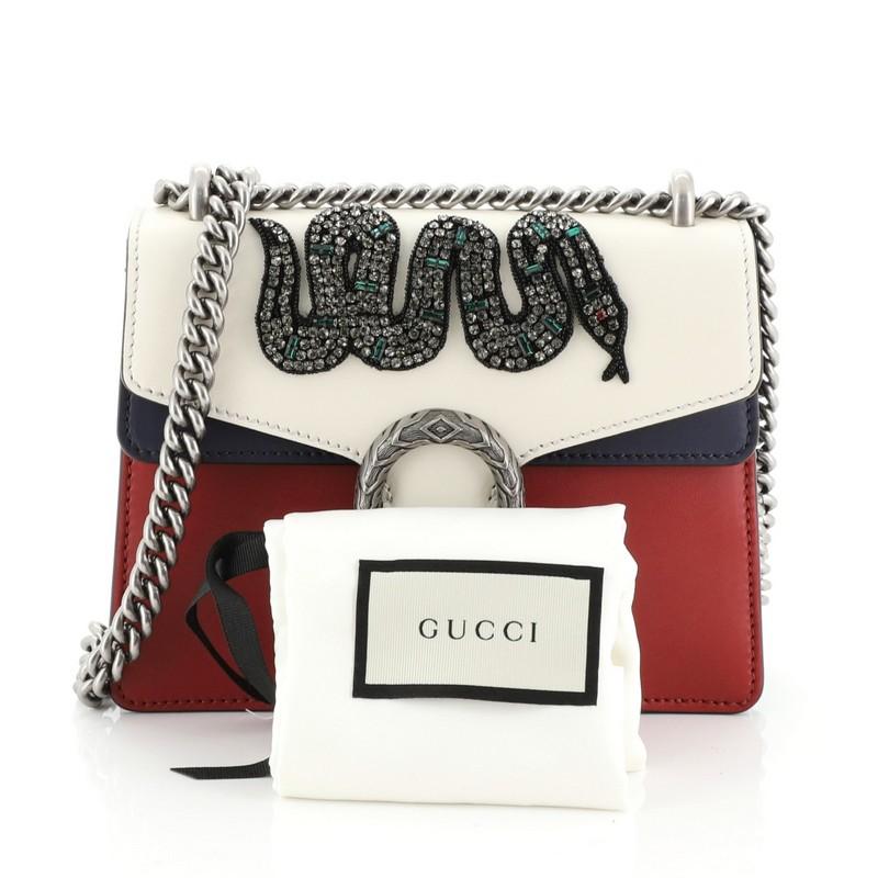 This Gucci Dionysus Bag Embellished Leather Mini, crafted from red and multicolor embellished leather, features a chain link strap, textured tiger head spur detail on its flap, and aged silver-tone hardware. Its hidden push-pin closure opens to a