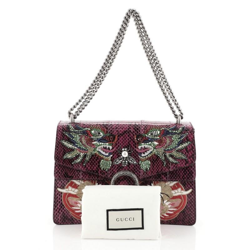 This Gucci Dionysus Bag Embellished Python Medium, crafted from genuine purple python with embellishments, features aged silver chain link strap, textured tiger head spur detail on its flap, accordion-like gusseted paneling and aged silver-tone