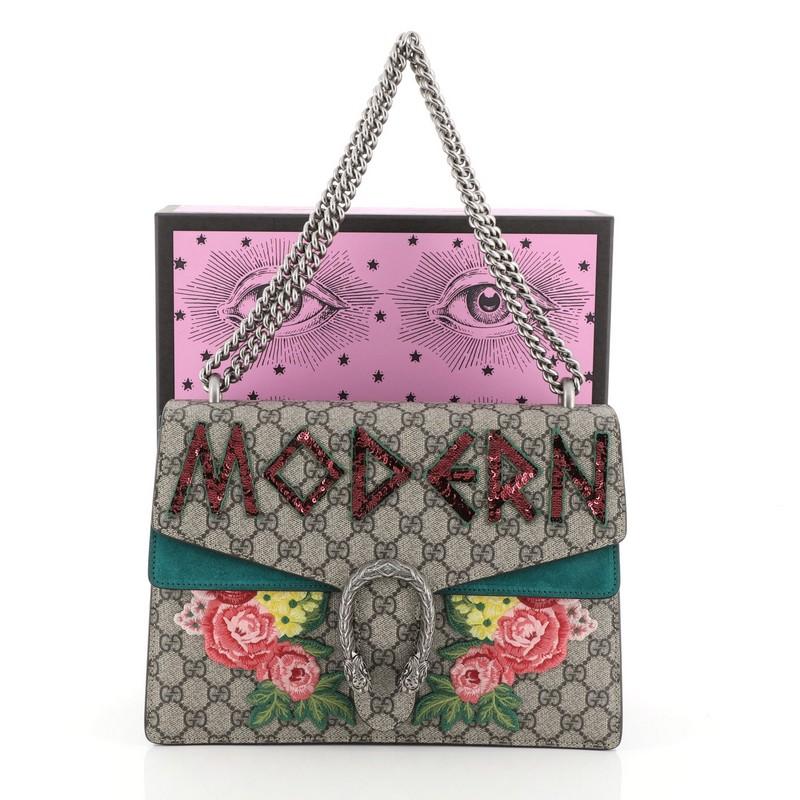 This Gucci Dionysus Bag Embroidered GG Coated Canvas Medium, crafted from brown embroidered GG coated canvas, features chain link strap, textured tiger head spur detail on its flap, accordion-like suede paneling, and aged silver-tone hardware. Its