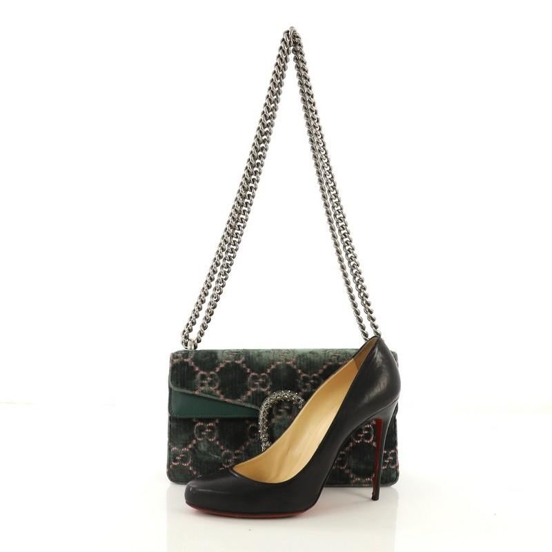 This Gucci Dionysus Bag GG Velvet Mini, crafted from green GG velvet, features chain link strap, textured tiger head spur detail on its flap, and aged silver-tone hardware. Its hidden push-pin closure opens to a blue satin interior. **Note: Shoe