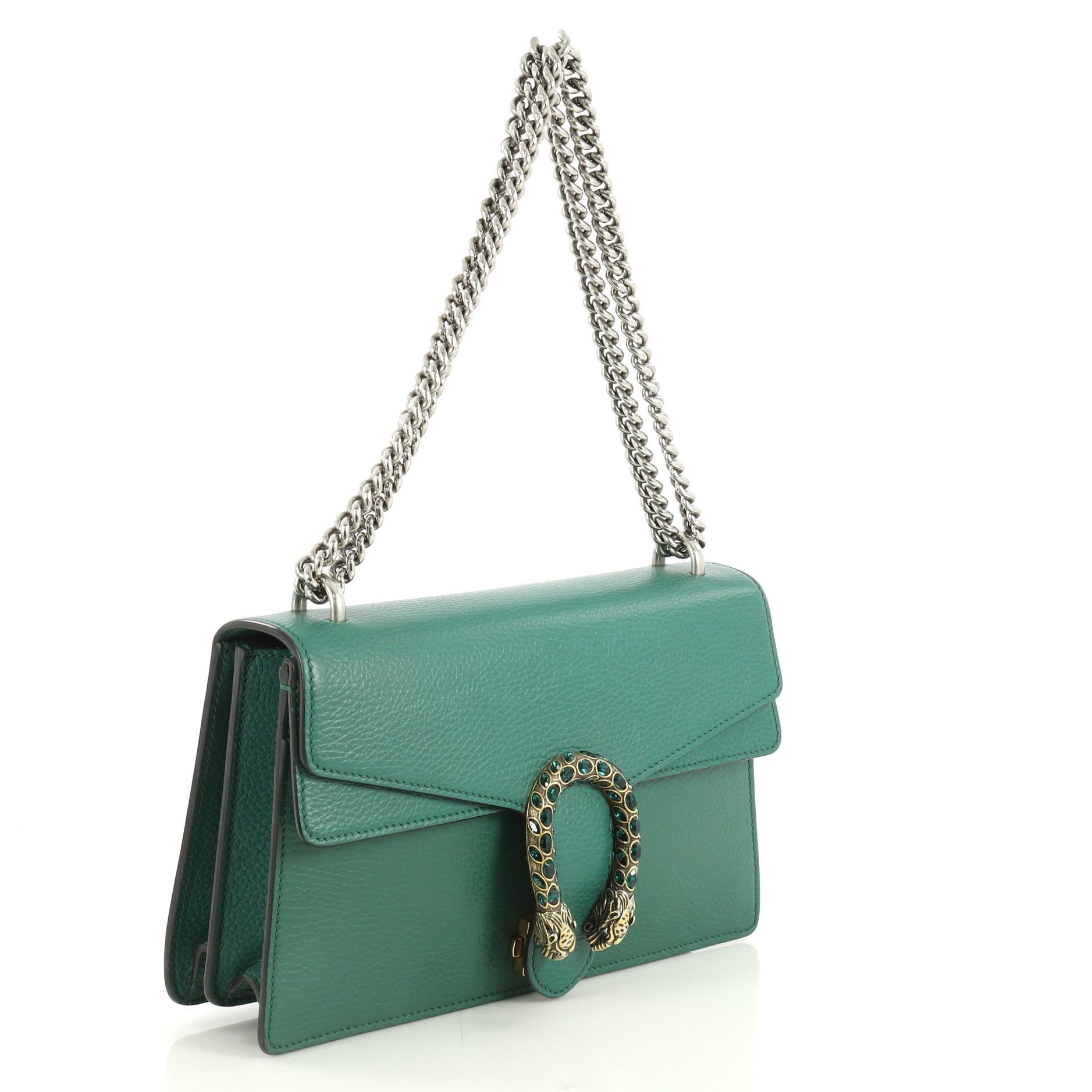 This Gucci Dionysus Bag Leather Small, crafted from green leather, features a chain link strap, embellished tiger head spur detail on its flap, accordion-like gusseted sides, and aged silver and aged gold-tone hardware. Its hidden push-pin closure