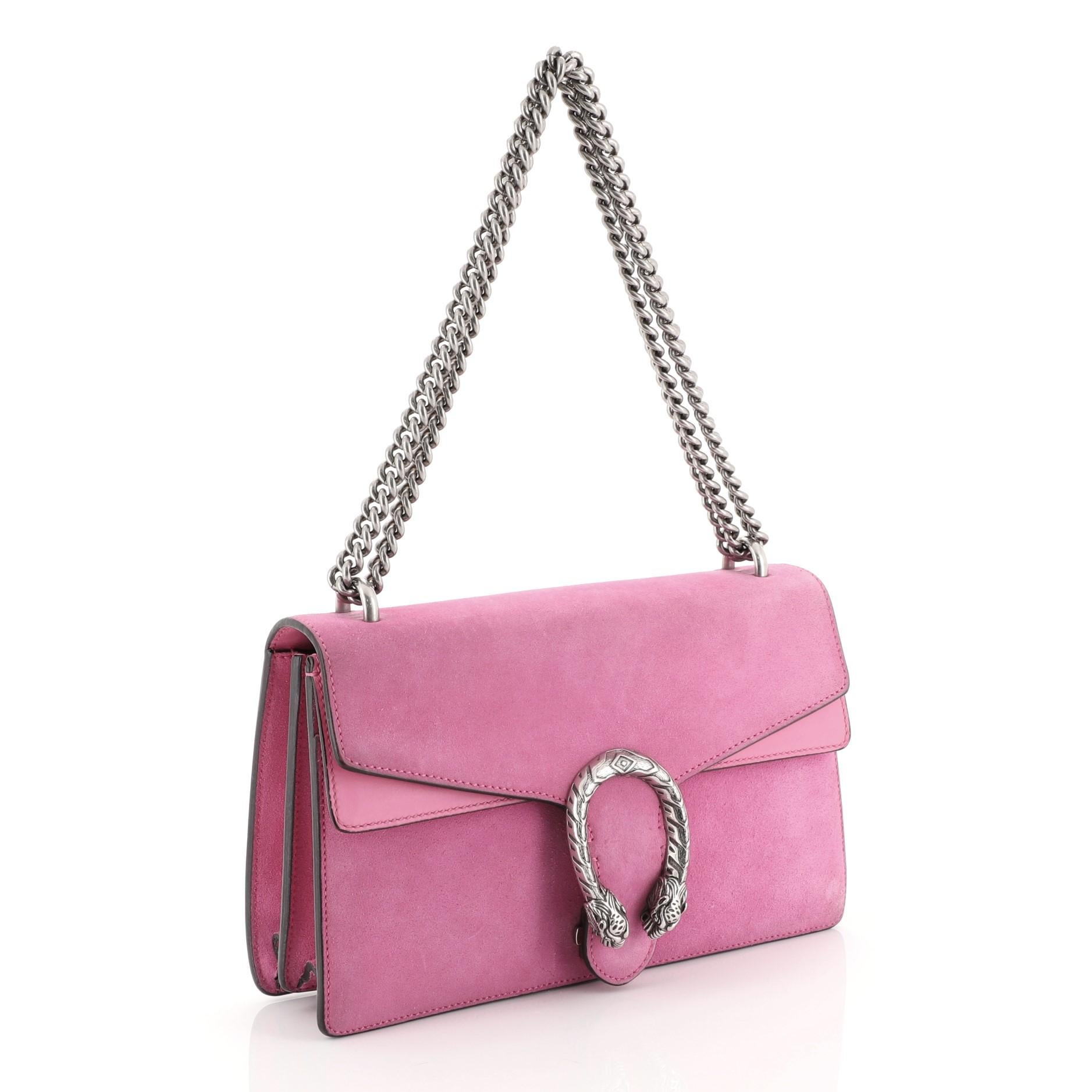 This Gucci Dionysus Bag Suede Small, crafted from pink suede, features a chain link strap, embellished tiger head spur detail on its flap, accordion-like gusseted sides, and aged silver-tone hardware. Its hidden push-pin closure opens to a pink