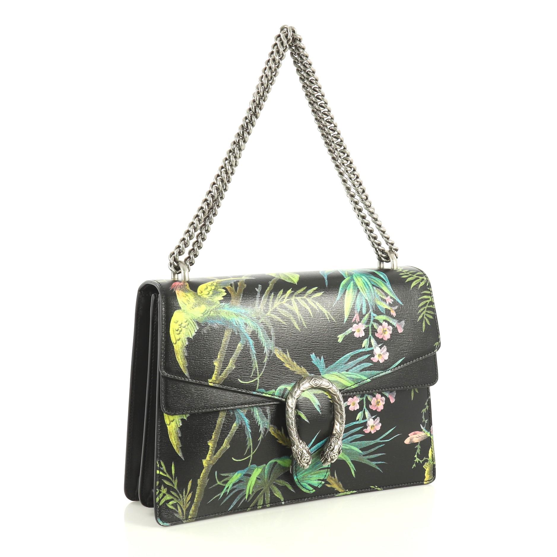 This Gucci Dionysus Bag Tropical Print Leather Medium, crafted from black printed leather, features chain link strap, textured tiger head spur detail on its flap, tropical print motif and aged silver-tone hardware. Its hidden push-pin closure opens