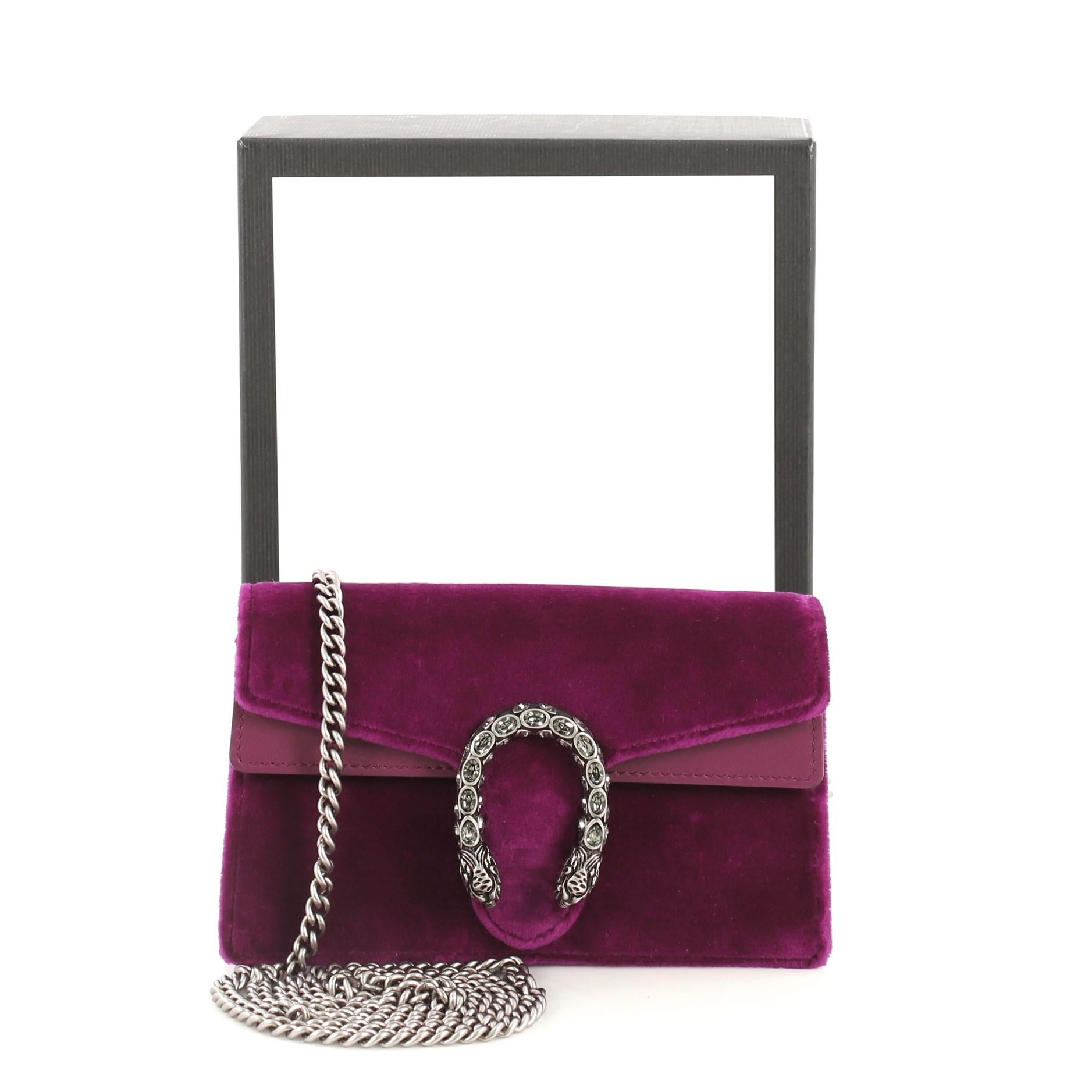 This Gucci Dionysus Bag Velvet Super Mini, crafted from purple velvet, features chain link strap, textured tiger head spur detail on its flap, and aged silver-tone hardware. Its hidden push-pin closure opens to a neutral microfiber interior.
